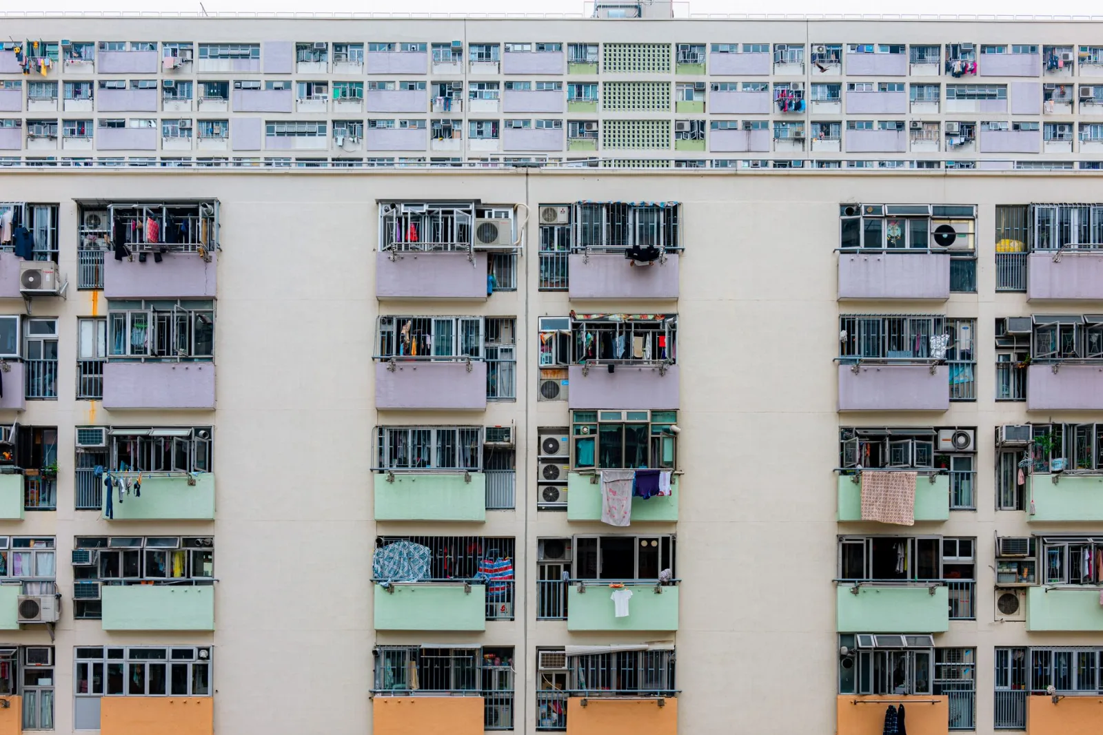 Fațada unui bloc de apartamente cu multe balcoane și ferestre
