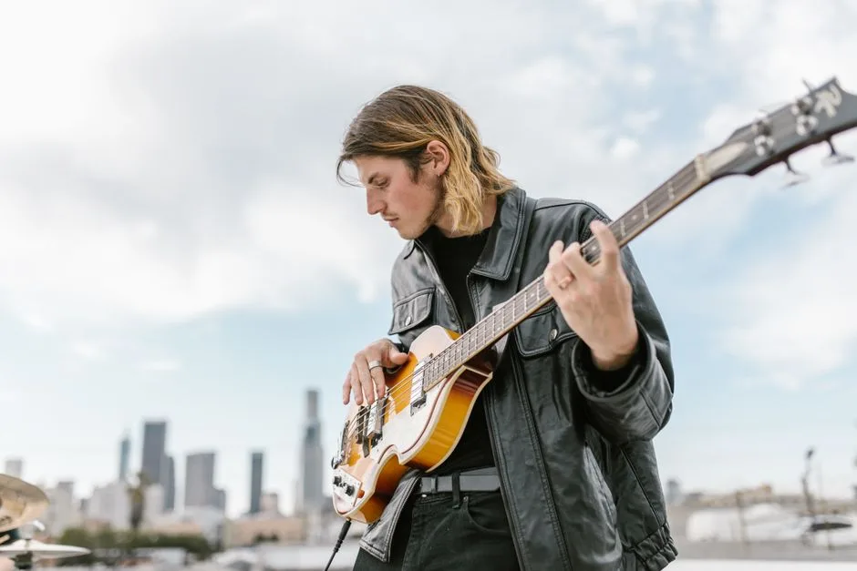 Tânăr muzician cântând la o chitară bass electrică